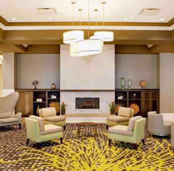 The hotel’s lobby lounge includes a fireplace, armchairs and coffee tables set in a spacious environment.