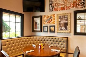 The Burger Place is Sonesta Atlanta Airport South’s on-site restaurant, and includes burger-related art on the wall alongside a widescreen TV, and large windows.