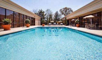 The hotel’s outdoor pool has potted plants by the side, in addition to shaded tables and chairs.