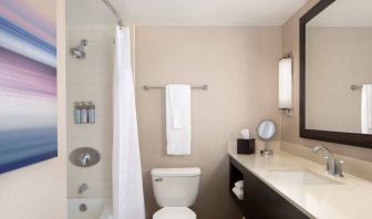 Guest bathroom in Sonesta San Jose, featuring bath with a shower, lavatory, and window and sink.