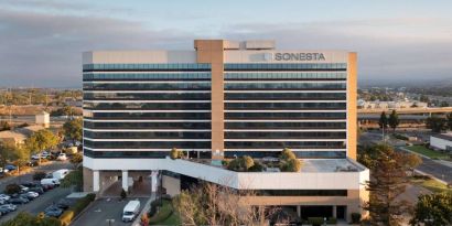 Sonesta San Jose’s exterior has ample parking for guests, abundant greenery, and a pool, plus the hotel chain’s name on the outside of the top floor.