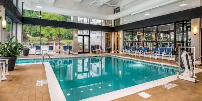 The hotel’s indoor pool includes a lift, has chairs by the side, and large windows to let in plenty of natural light.