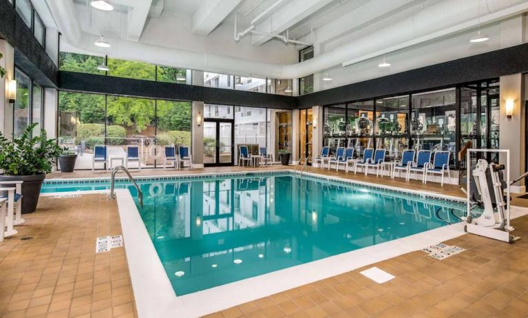 The hotel’s indoor pool includes a lift, has chairs by the side, and large windows to let in plenty of natural light.