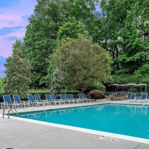 The outdoor pool at Sonesta Charlotte Executive Park has chairs by the side, is close to the fire pit, and connects directly to the indoor pool.