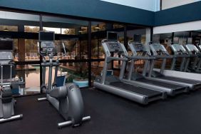 The fitness center at Sonesta Charlotte Executive Park has assorted exercise machines, and large windows that overlook the pool.