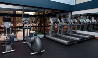 The fitness center at Sonesta Charlotte Executive Park has assorted exercise machines, and large windows that overlook the pool.