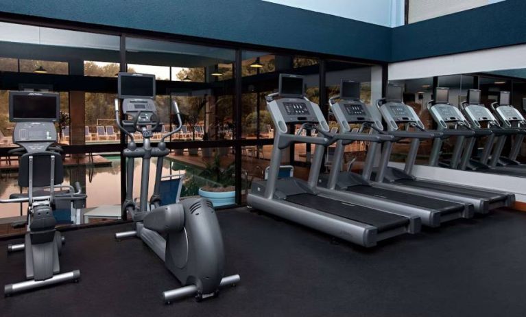 The fitness center at Sonesta Charlotte Executive Park has assorted exercise machines, and large windows that overlook the pool.