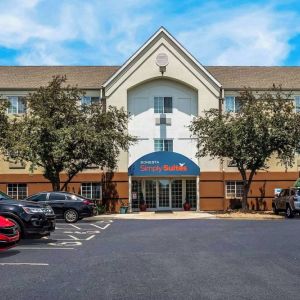 Sonesta Simply Suites St Louis Earth City’s exterior includes numerous parking spaces (including disabled spaces near the covered entrance) and trees.