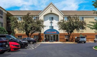 Sonesta Simply Suites St Louis Earth City’s exterior includes numerous parking spaces (including disabled spaces near the covered entrance) and trees.