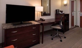 Sonesta Chicago O'Hare Airport Rosemont guest room workspace, including desk, chair, lamp, telephone, and nearby TV.