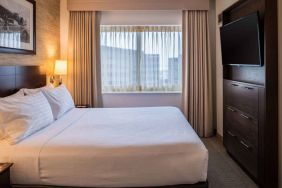 Sonesta Chicago O'Hare Airport Rosemont double bed guest room with window and wall-mounted TV.