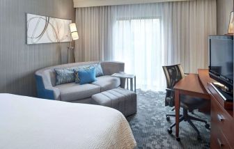 Delux king room with couch and workspace at Sonesta Select Milwaukee Brookfield.