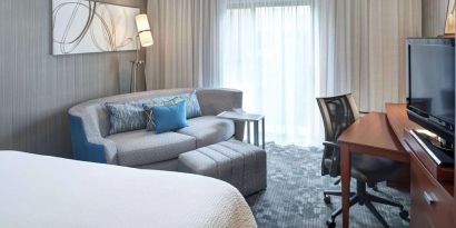 Delux king room with couch and workspace at Sonesta Select Milwaukee Brookfield.