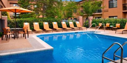 The hotel’s outdoor pool has a direct water link to the indoor pool, and has a shaded table and chairs as well as sun loungers by the side.