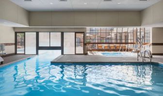 The hotel’s indoor pool has an adjacent hot tub and large windows, with a direct water link to the outdoor pool. 