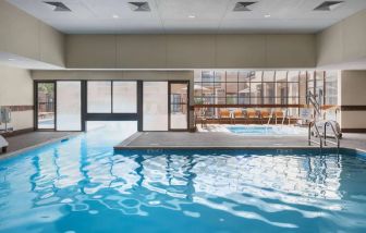 The hotel’s indoor pool has an adjacent hot tub and large windows, with a direct water link to the outdoor pool. 