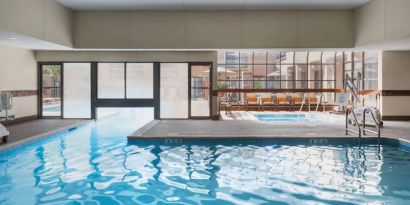 The hotel’s indoor pool has an adjacent hot tub and large windows, with a direct water link to the outdoor pool. 