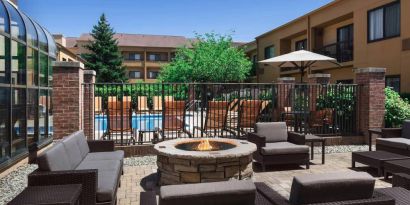 Sonesta Select Newport Middletown’s fire pit has comfortable armchair and sofa seating nearby, and is close to the pool.