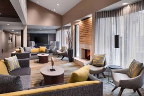 Sonesta Select Newport Middletown’s lobby lounge is furnished with comfy chairs and corners sofas, a fireplace and coffee tables, plus large windows.