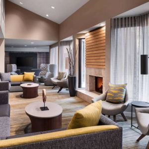 Sonesta Select Newport Middletown’s lobby lounge is furnished with comfy chairs and corners sofas, a fireplace and coffee tables, plus large windows.