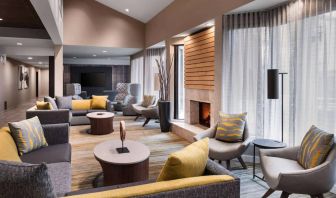 Sonesta Select Newport Middletown’s lobby lounge is furnished with comfy chairs and corners sofas, a fireplace and coffee tables, plus large windows.