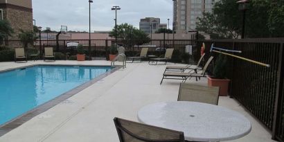 Sonesta ES Suites San Antonio Northwest - Medical Center’s outdoor pool is ringed by a fence, and has nearby tables and chairs, as well as sun loungers.