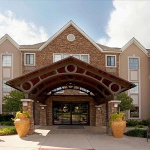 Sonesta ES Suites San Antonio Northwest - Medical Center’s exterior has pleasant greenery and benches, and a covered entranceway.