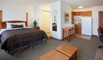 Double bed guest room in Sonesta ES Suites San Antonio Northwest - Medical Center, featuring kitchen area with fridge-freezer and microwave.