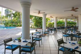 The hotel’s breakfast area has a hard floor, numerous ceiling fans, and small tables within easy reach of the pool.