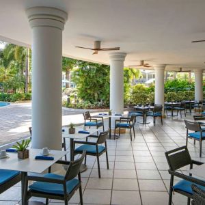 The hotel’s breakfast area has a hard floor, numerous ceiling fans, and small tables within easy reach of the pool.