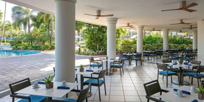 The hotel’s breakfast area has a hard floor, numerous ceiling fans, and small tables within easy reach of the pool.