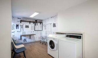 The hotel’s laundry room features a washer and drier, a pair of baskets, plus shelves and chairs.