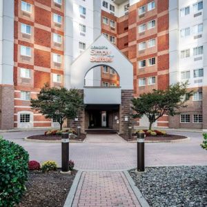 The hotel’s exterior has a brickwork surface, with flowers and trees either side of the entrance, which has the Sonesta Simply Suites name on it.