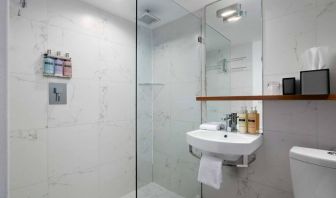 Guest bathroom in Nautilus by Sonesta, including shower, sink, mirror, and lavatory.