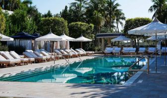 Nautilus by Sonesta’s outdoor pool has sun loungers (with shade available) by the side, and palm trees looming in the background.