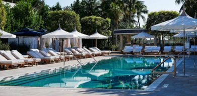 Nautilus by Sonesta’s outdoor pool has sun loungers (with shade available) by the side, and palm trees looming in the background.