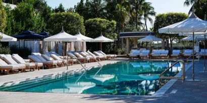 Nautilus by Sonesta’s outdoor pool has sun loungers (with shade available) by the side, and palm trees looming in the background.