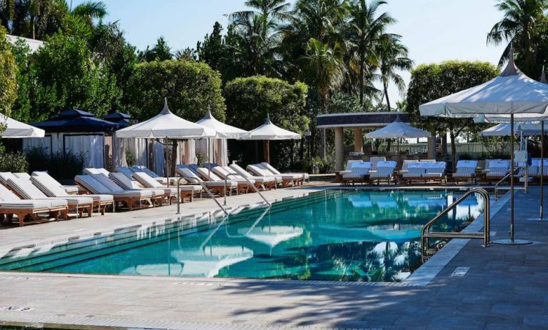 Nautilus by Sonesta’s outdoor pool has sun loungers (with shade available) by the side, and palm trees looming in the background.