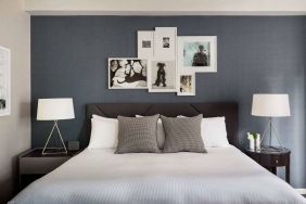 The Shelburne Sonesta New York double bed guest room, with art on the walls and bedside lamps.