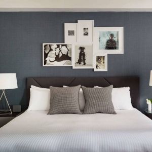 The Shelburne Sonesta New York double bed guest room, with art on the walls and bedside lamps.