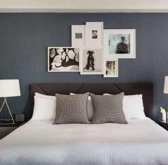 The Shelburne Sonesta New York double bed guest room, with art on the walls and bedside lamps.