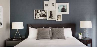 The Shelburne Sonesta New York double bed guest room, with art on the walls and bedside lamps.