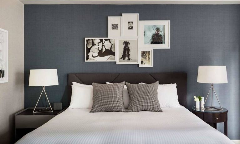 The Shelburne Sonesta New York double bed guest room, with art on the walls and bedside lamps.