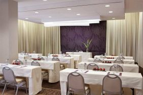 The Shelburne Sonesta New York meeting room with tables arranged in a classroom style facing a head table and space for over a dozen attendees.