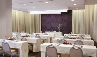 The Shelburne Sonesta New York meeting room with tables arranged in a classroom style facing a head table and space for over a dozen attendees.