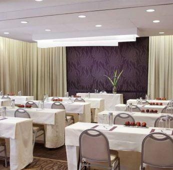 The Shelburne Sonesta New York meeting room with tables arranged in a classroom style facing a head table and space for over a dozen attendees.