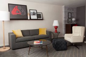 The Fifty Sonesta Select New York guest room living area, furnished with sofa, chair, coffee table, and artwork.