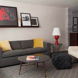 The Fifty Sonesta Select New York guest room living area, furnished with sofa, chair, coffee table, and artwork.