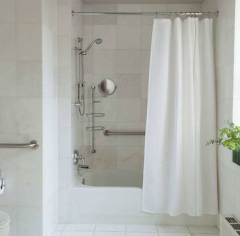 Guest bathroom in The Benjamin Royal Sonesta New York, featuring bath, shower, lavatory, and a small potted plant.