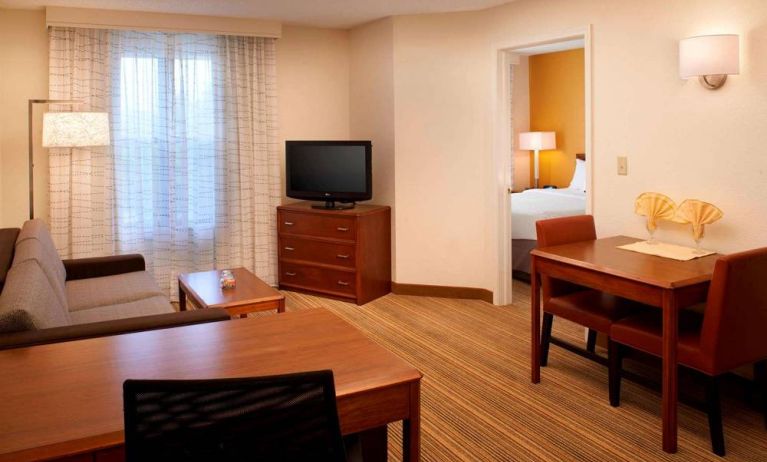 Sonesta ES Suites Chicago Waukegan Gurnee double bed guest room lounge area, featuring sofa, coffee table, and TV.